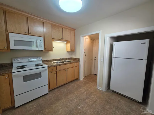 a kitchen with a refrigerator sink stove and cabinets