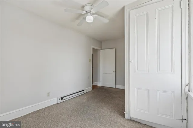 an empty room with a ceiling fan and a window