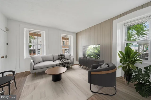 a living room with furniture potted plant and a window