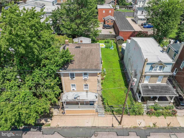 an aerial view of a house with garden space and street view