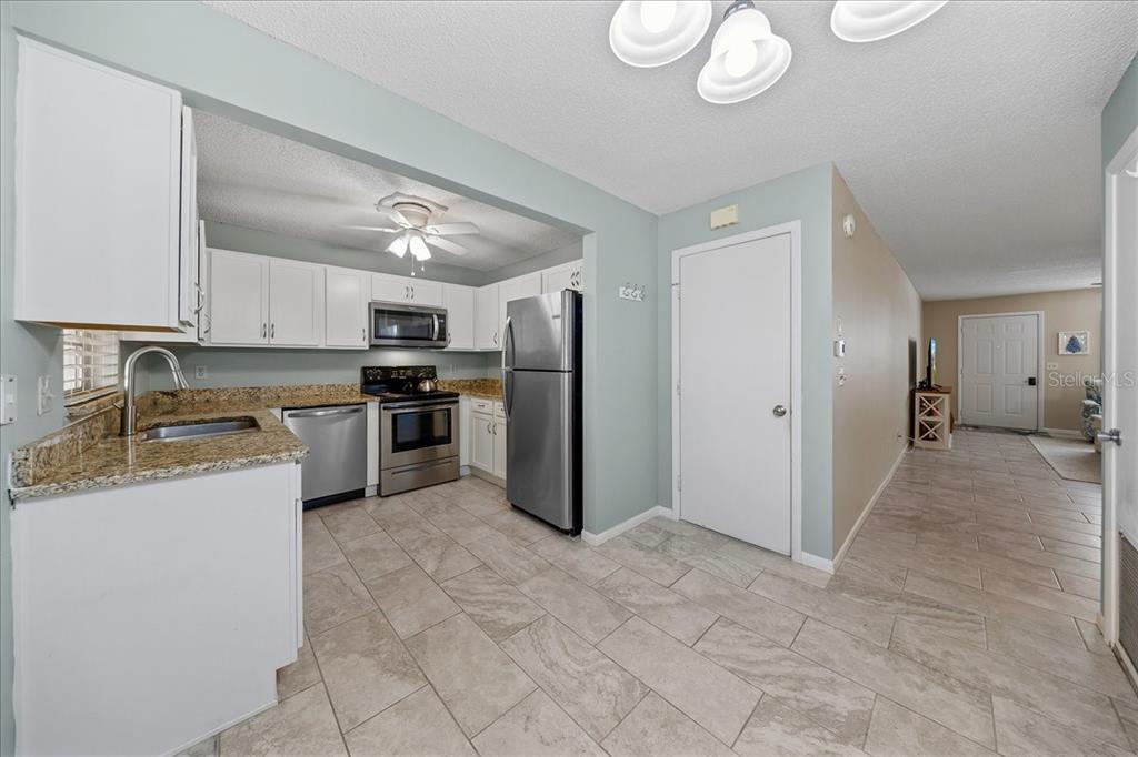 8877 Southwest 96th Street, Unit B Ocala, FL 34481 - Photo 13 of 48 a kitchen with stainless steel appliances granite countertop a refrigerator and a stove top oven