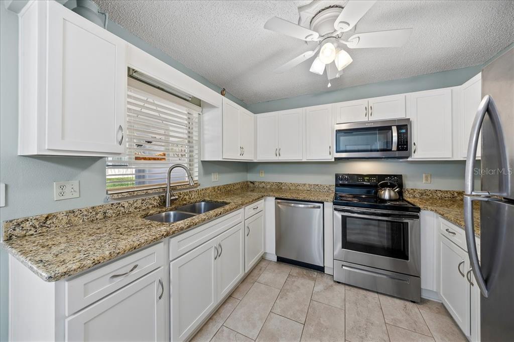 8877 Southwest 96th Street, Unit B Ocala, FL 34481 - Photo 15 of 48 a kitchen with stainless steel appliances granite countertop a sink and a stove