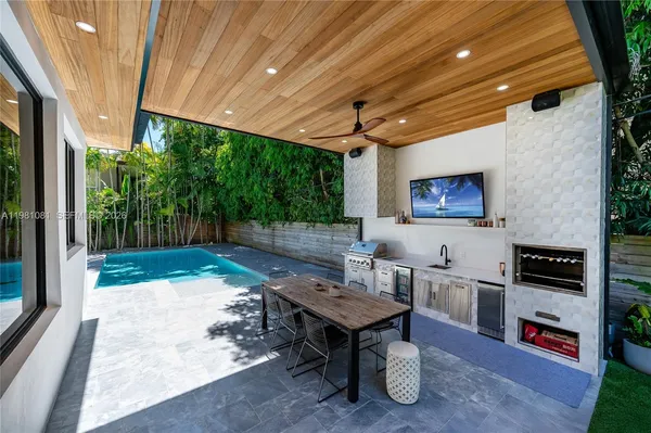 a backyard of a house with barbeque oven table and chairs