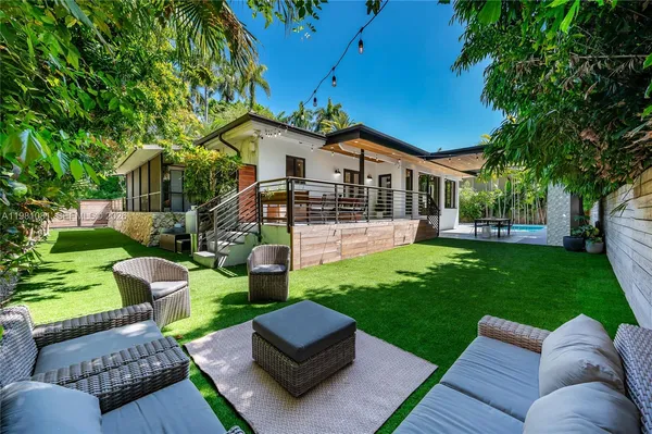 a view of a patio with couches chairs and a yard