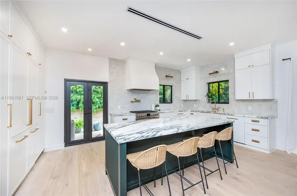 a kitchen with a table chairs sink and cabinets