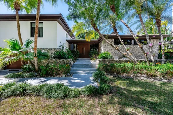 a view of house with backyard and outdoor seating