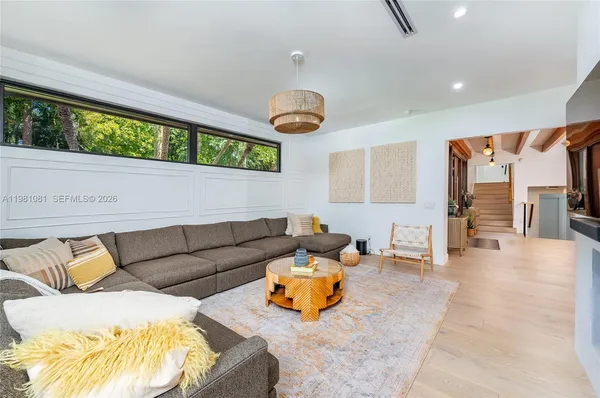 a living room with furniture and wooden floors