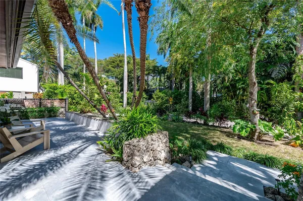 a view of backyard with outdoor seating and plants