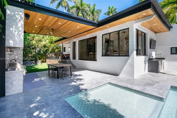 a view of a patio with table and chairs next to a yard