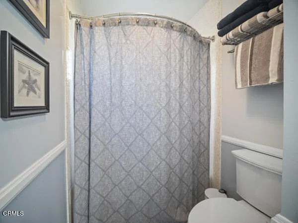 a bathroom with a shower curtain and a toilet