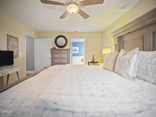 a bedroom with a bed and a tv on dresser