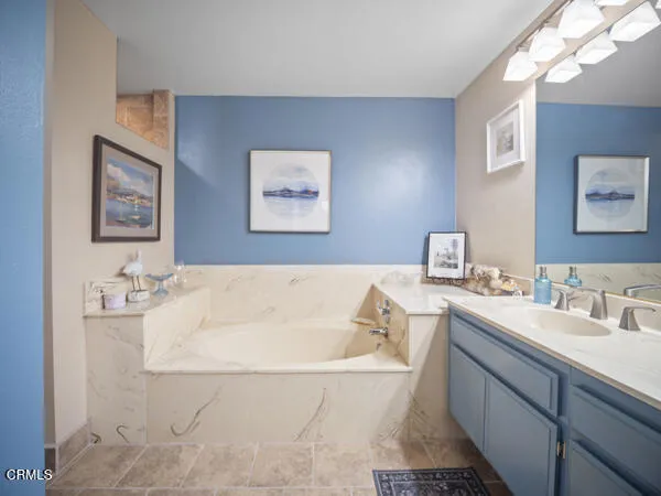 a bathroom with a tub sink and mirror