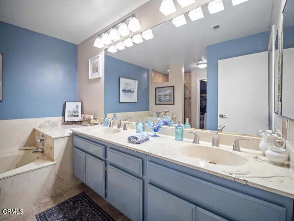 a bathroom with a granite countertop sink double vanity and a mirror