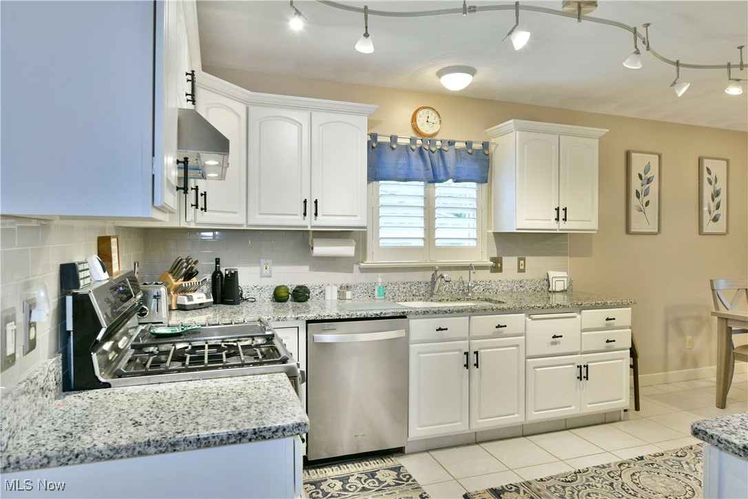 159 Mathews Road, Unit B Youngstown, OH 44512 - Photo 20 of 50 Kitchen with light tile patterned flooring, sink, tasteful backsplash, white cabinetry, and appliances with stainless steel finishes