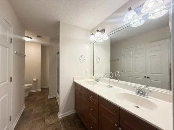 a bathroom with a double vanity sink mirror and shower