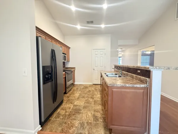 a kitchen with stainless steel appliances granite countertop a refrigerator and a stove