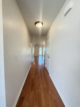 a view of a hallway with wooden floor