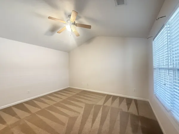 a view of a room with a ceiling fan and a window