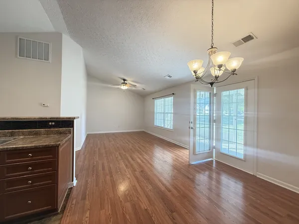 a view of a livingroom with a ceiling fan window and wooden floor