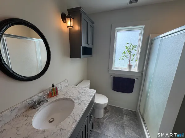 a bathroom with a granite countertop sink and a mirror