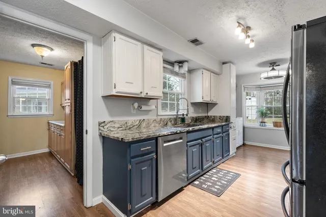 a kitchen with granite countertop a sink stove and refrigerator