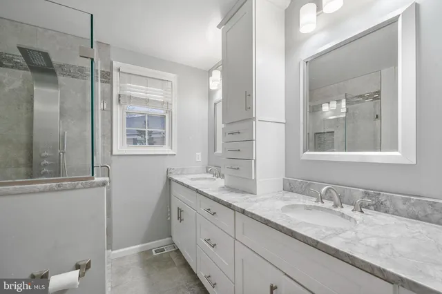 a bathroom with a granite countertop sink mirror and double