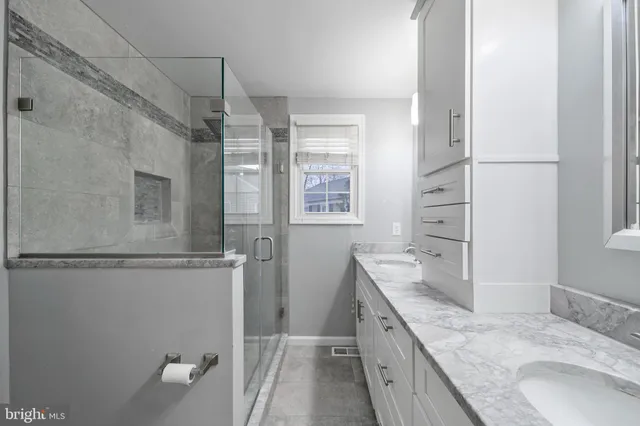 a bathroom with a granite countertop sink a mirror and a bathtub