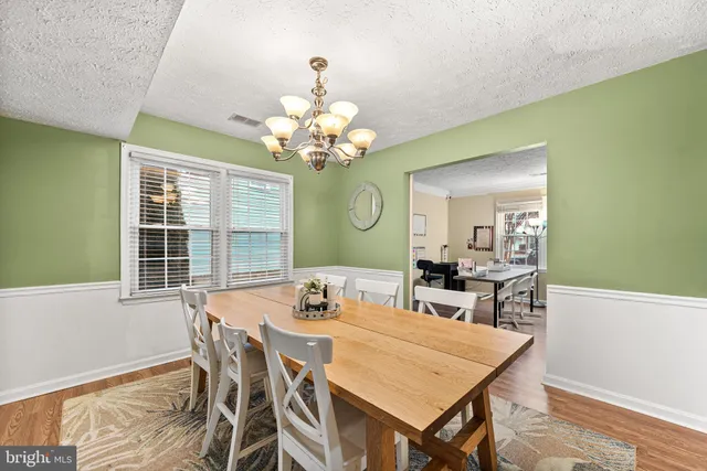 a view of a dining room with furniture a chandelier and wooden floor