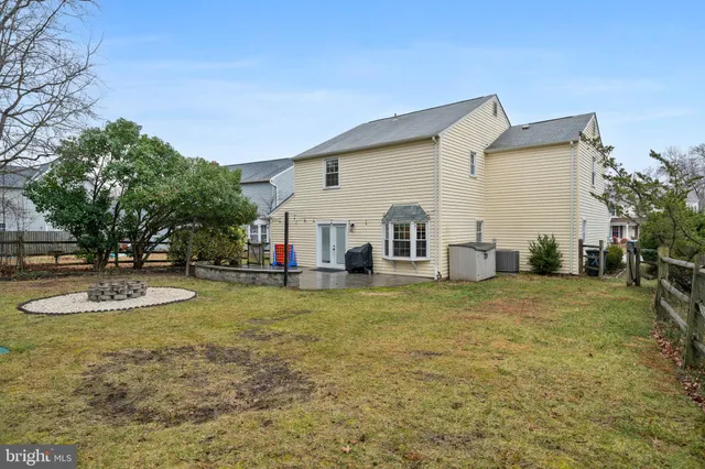 a view of a white house with a small yard and a large tree