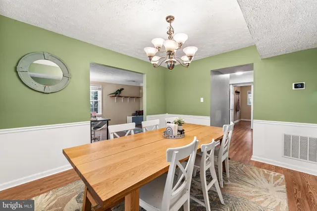 a view of a dining room with furniture and a chandelier