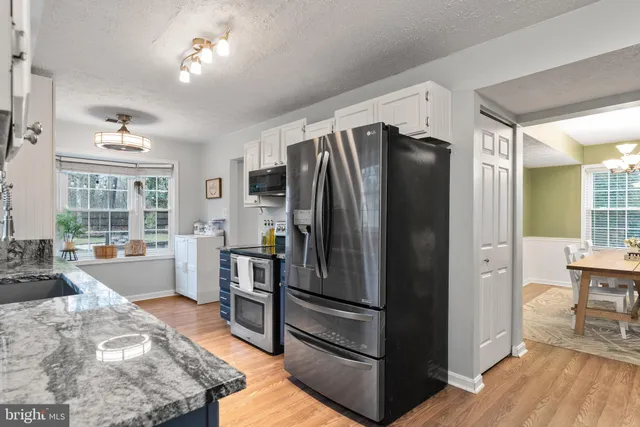 a kitchen with stainless steel appliances granite countertop a refrigerator and a stove