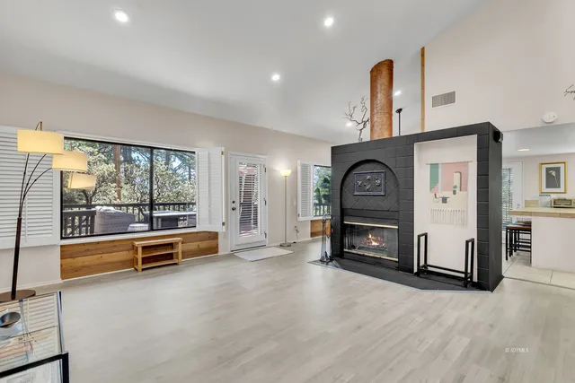 a view of a livingroom with furniture wooden floor window and fireplace