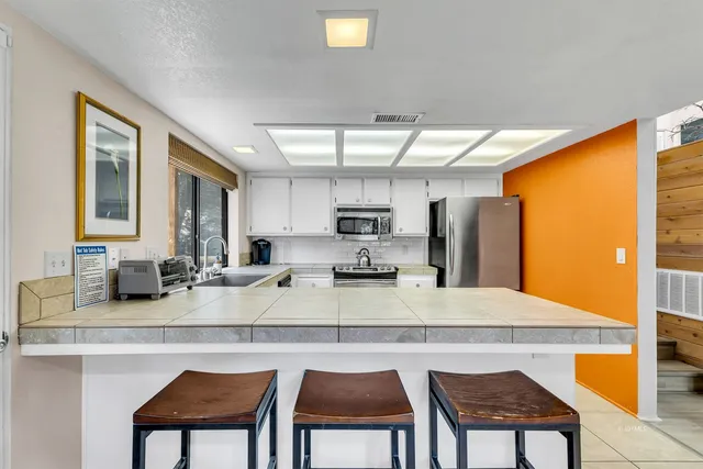 a view of an empty room with window and chandelier