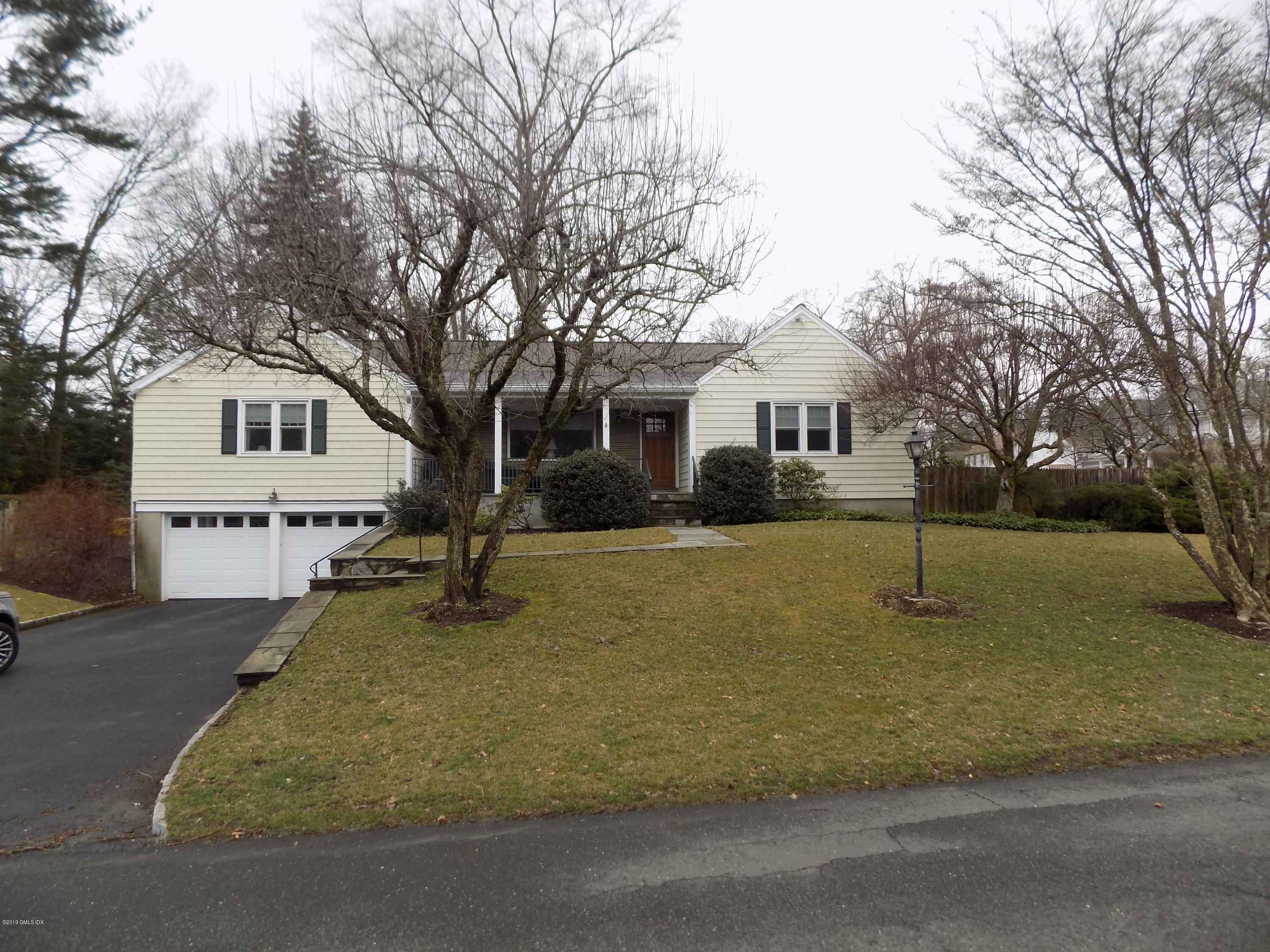 a white house that has tree in front of it