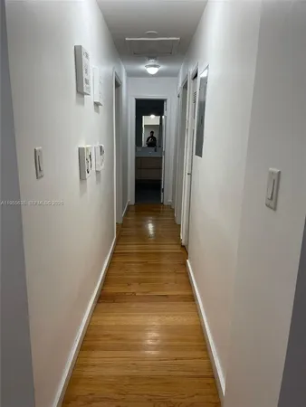 a view of a hallway with wooden floor and a hallway