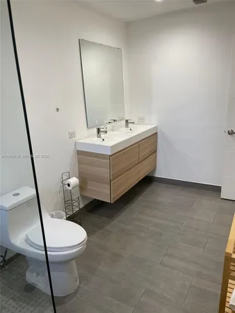 a bathroom with a sink mirror vanity and toilet