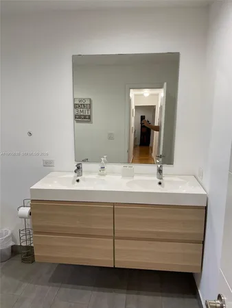 a bathroom with a sink vanity and mirror
