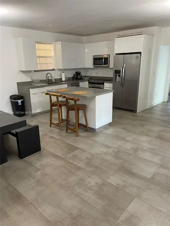 a kitchen with stainless steel appliances a stove a sink a microwave a refrigerator and cabinets