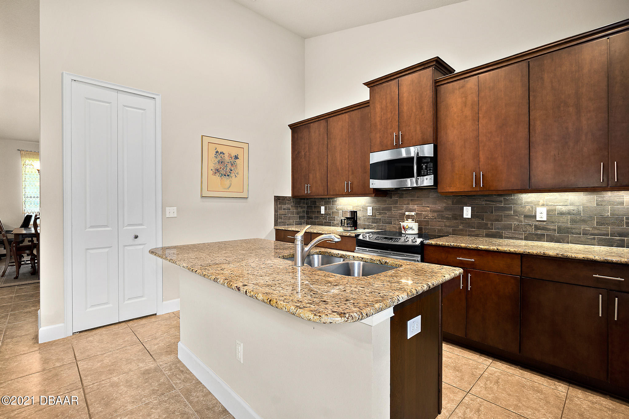667 Elk River Drive Ormond Beach, FL 32174 - Photo 5 of 49 a kitchen with granite countertop a sink and a stove top oven
