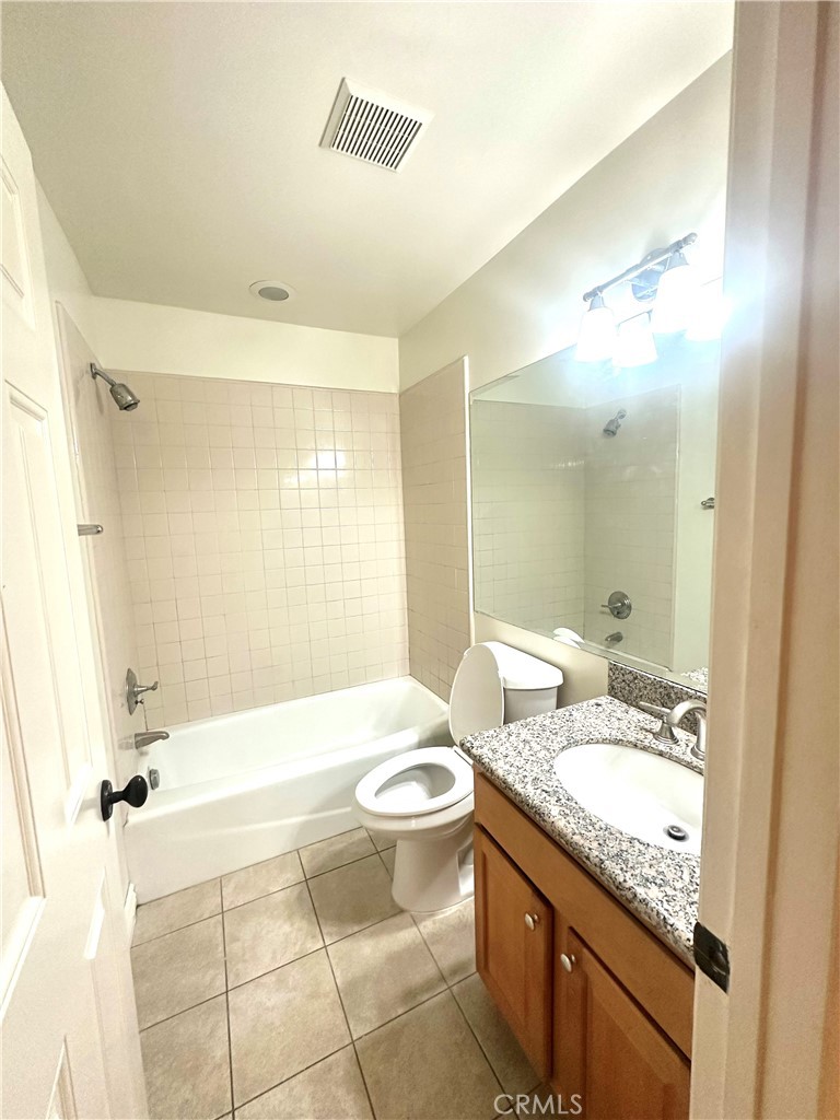 9356 19th Street, Unit A Rancho Cucamonga, CA 91701 - Photo 9 of 23 a bathroom with a granite countertop sink toilet mirror and bathtub