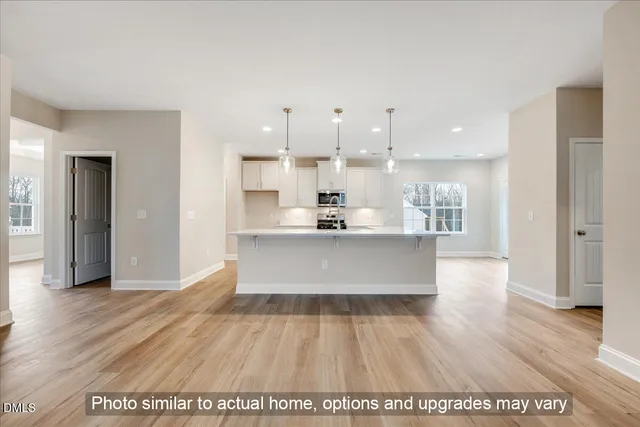 a large white kitchen with a sink and chandelier