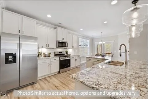 a view of kitchen with stainless steel appliances cabinets a sink and a wooden floor