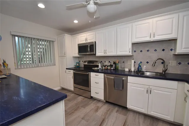a kitchen with granite countertop white cabinets and white appliances