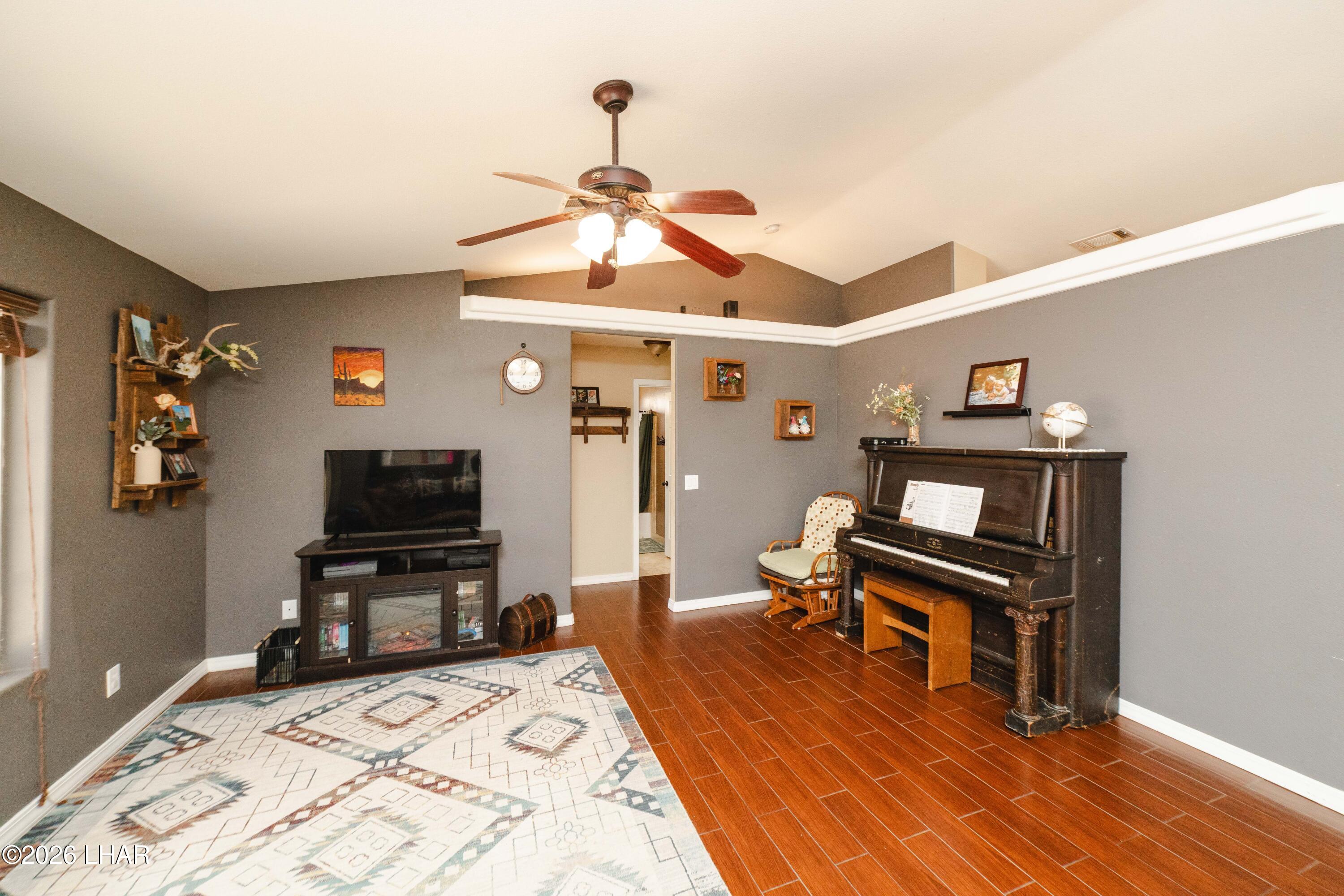 2177 Ridgeview Road Kingman, AZ 86401 - Photo 11 of 43 Spacious living area featuring wood-finish flooring, a vaulted ceiling, and ample natural light from multiple windows