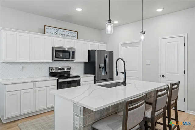 a kitchen with kitchen island a sink stove and refrigerator