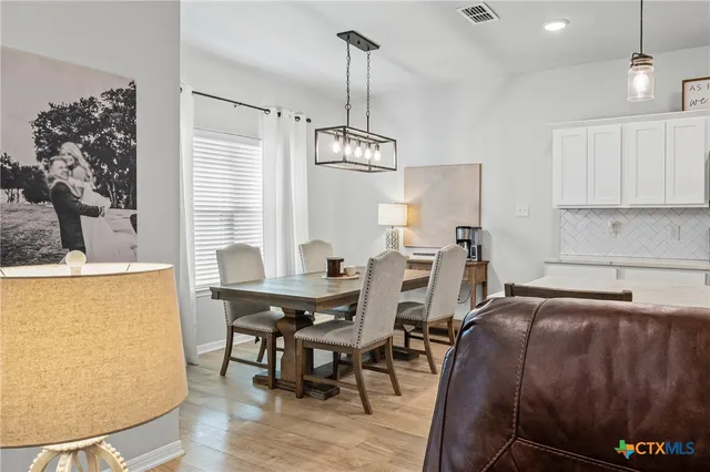 a kitchen with stainless steel appliances a table and chairs in it