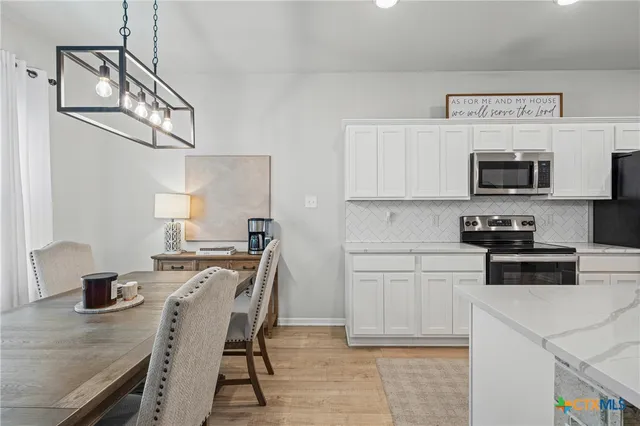 a kitchen with stainless steel appliances a stove a sink a microwave a refrigerator and cabinets