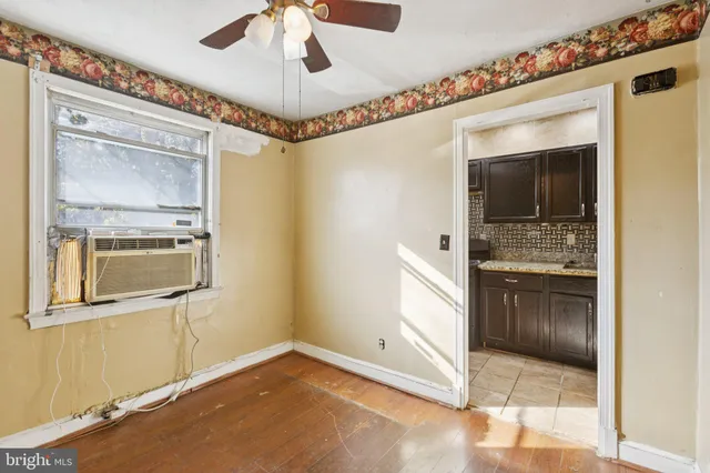 a view of a hallway with wooden floor and a living room