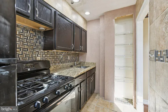 a kitchen with stainless steel appliances granite countertop a stove and a sink