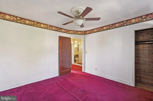 an empty room with a window and wooden floor